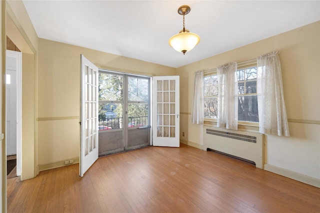 doorway to outside with hardwood / wood-style floors and radiator