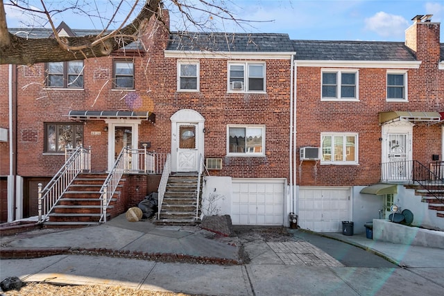 multi unit property featuring a garage and an AC wall unit