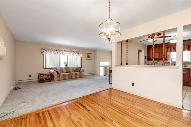 unfurnished living room with a notable chandelier, light hardwood / wood-style floors, and baseboard heating