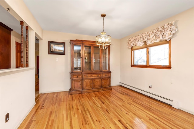 unfurnished dining area featuring baseboard heating, an inviting chandelier, and light wood-type flooring