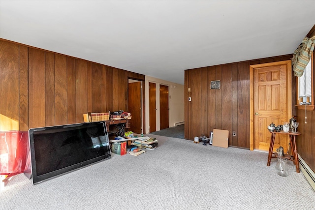 living room with wooden walls, carpet, and a baseboard heating unit