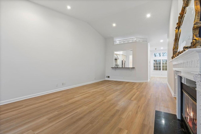 unfurnished living room with vaulted ceiling and light hardwood / wood-style floors