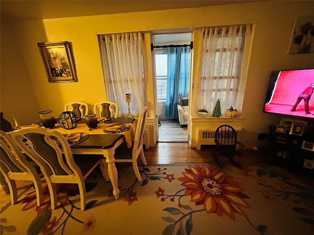 dining room with hardwood / wood-style flooring and radiator heating unit