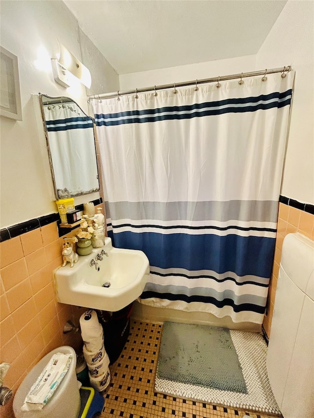 bathroom with tile walls, sink, and tile patterned flooring