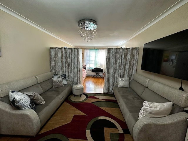 living room with a notable chandelier, ornamental molding, and hardwood / wood-style flooring