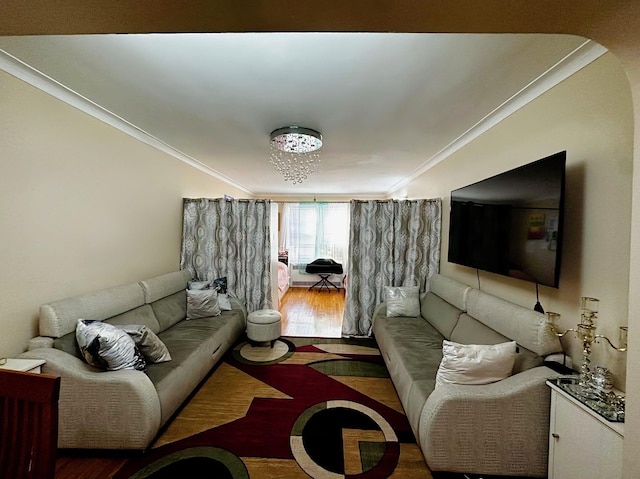 living room featuring ornamental molding, wood-type flooring, and a notable chandelier