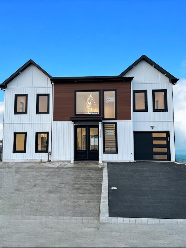 modern farmhouse style home featuring a garage and french doors