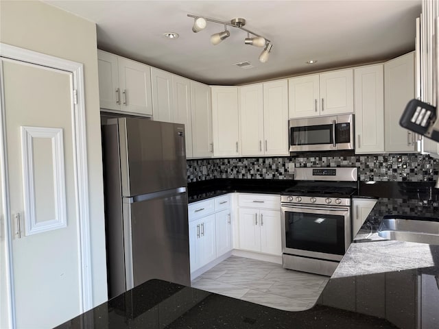 kitchen with stainless steel appliances, decorative backsplash, white cabinets, and sink