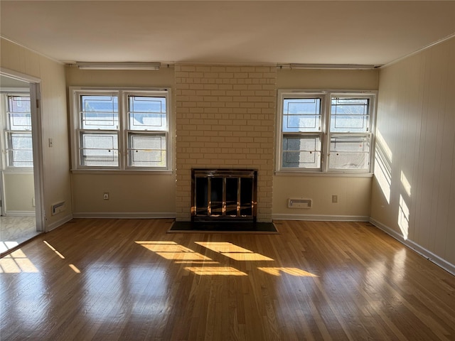 unfurnished living room featuring a fireplace, plenty of natural light, and dark hardwood / wood-style flooring