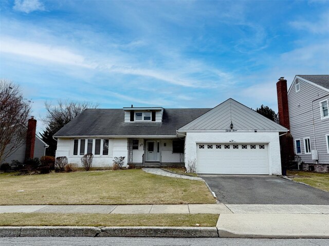 view of front of house featuring aphalt driveway, a garage, brick siding, and a front yard