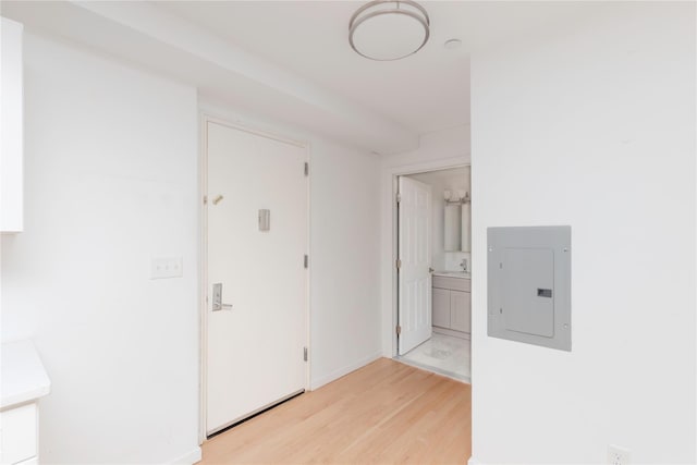 corridor with electric panel and light hardwood / wood-style floors