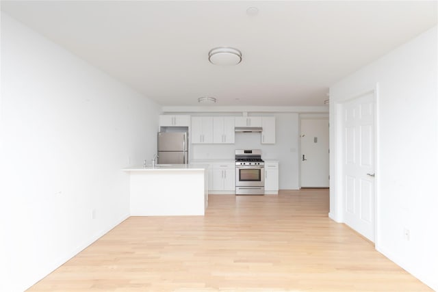 kitchen with sink, white cabinets, light hardwood / wood-style floors, kitchen peninsula, and stainless steel appliances