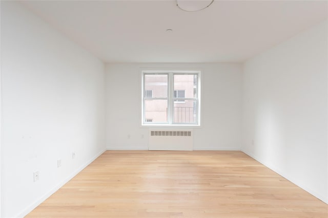 empty room featuring radiator and light hardwood / wood-style floors