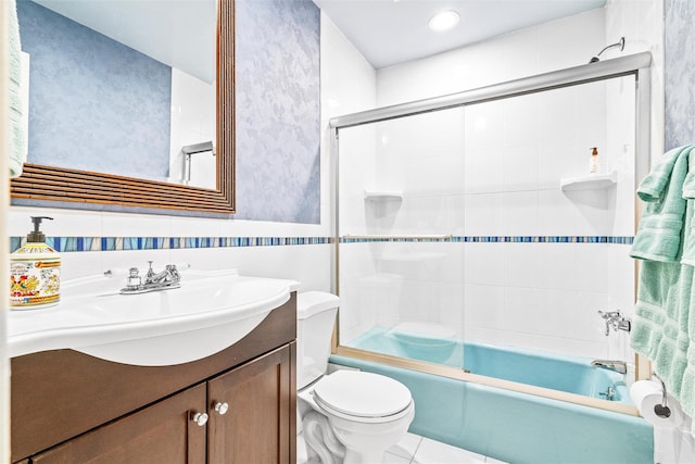 full bathroom featuring toilet, tile walls, tile patterned flooring, enclosed tub / shower combo, and vanity