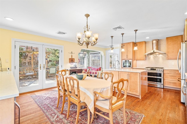 dining room with arched walkways, visible vents, light wood-style floors, and ornamental molding