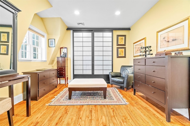 living area with light wood-type flooring, visible vents, and recessed lighting