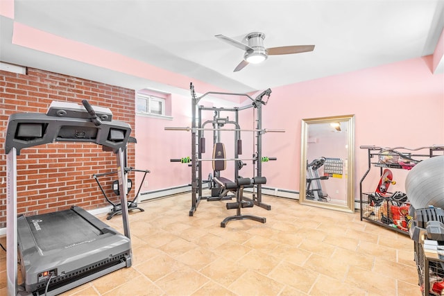 workout room featuring baseboard heating, a ceiling fan, and brick wall