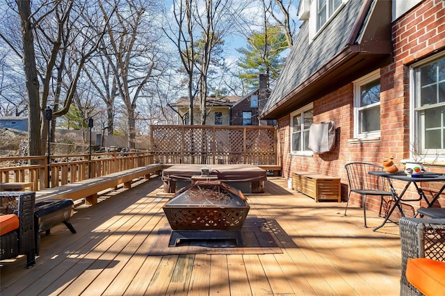 wooden deck with area for grilling and an outdoor fire pit