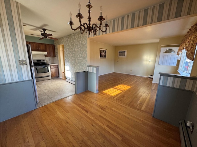 kitchen with an AC wall unit, light hardwood / wood-style floors, a baseboard radiator, and electric stove