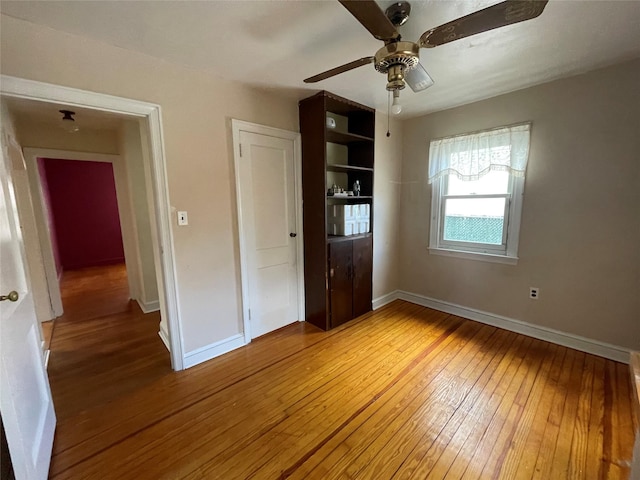 unfurnished bedroom featuring wood-type flooring and ceiling fan