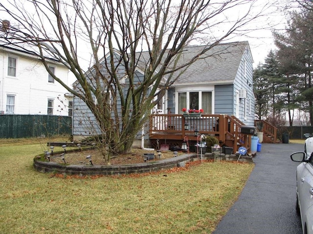 view of front facade featuring a deck and a front lawn