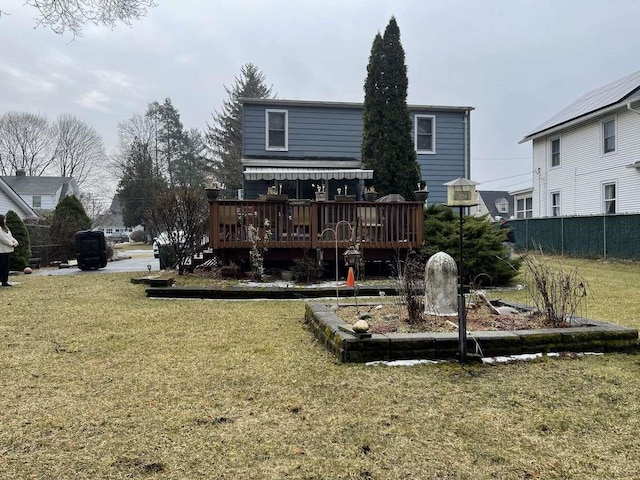 back of house featuring a wooden deck and a lawn