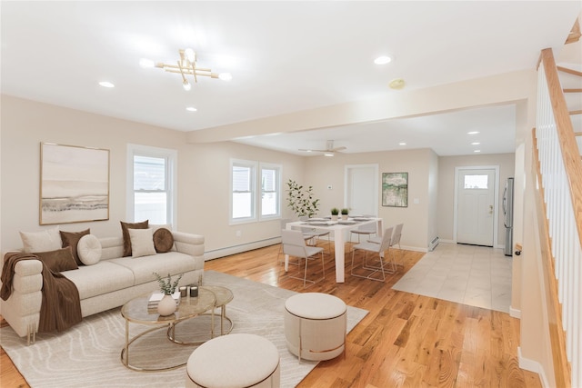 living room featuring light hardwood / wood-style flooring, a notable chandelier, and a baseboard radiator