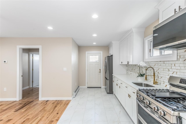 kitchen with sink, white cabinetry, backsplash, stainless steel appliances, and a baseboard heating unit