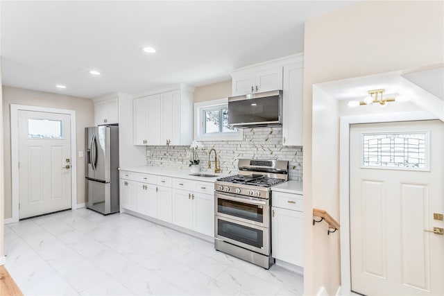 kitchen with white cabinetry, appliances with stainless steel finishes, sink, and tasteful backsplash