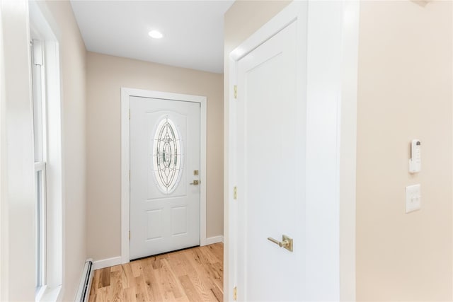 doorway to outside featuring baseboard heating and light wood-type flooring