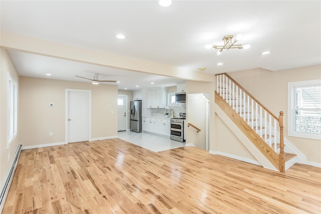 unfurnished living room with a baseboard radiator and light hardwood / wood-style flooring