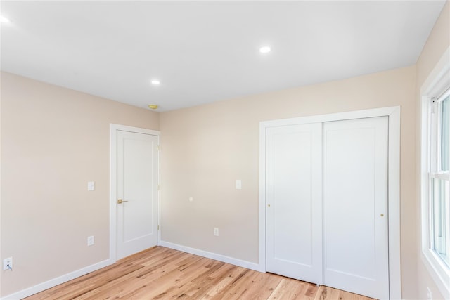 unfurnished bedroom featuring a closet and light hardwood / wood-style flooring