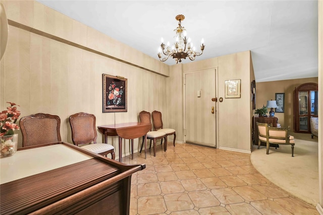 carpeted entryway with a notable chandelier