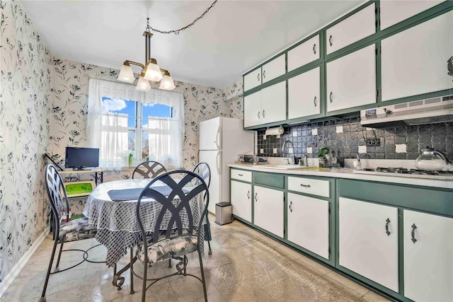 kitchen with pendant lighting, white cabinets, white appliances, tasteful backsplash, and sink