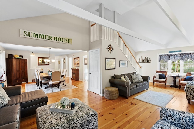 living room with a notable chandelier, a high ceiling, and hardwood / wood-style floors