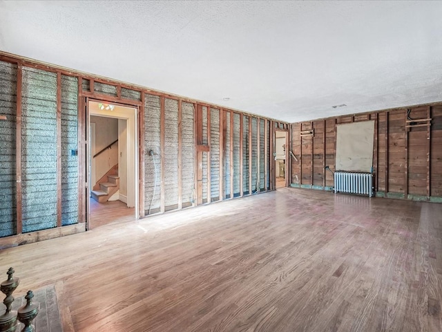 unfurnished living room with radiator and light wood-type flooring