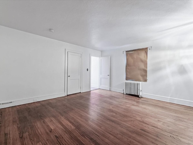 spare room with radiator and hardwood / wood-style floors