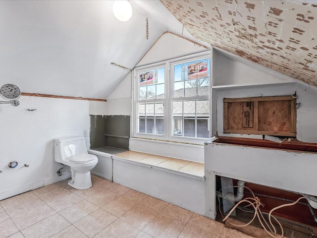 bathroom with tile patterned floors, toilet, and vaulted ceiling