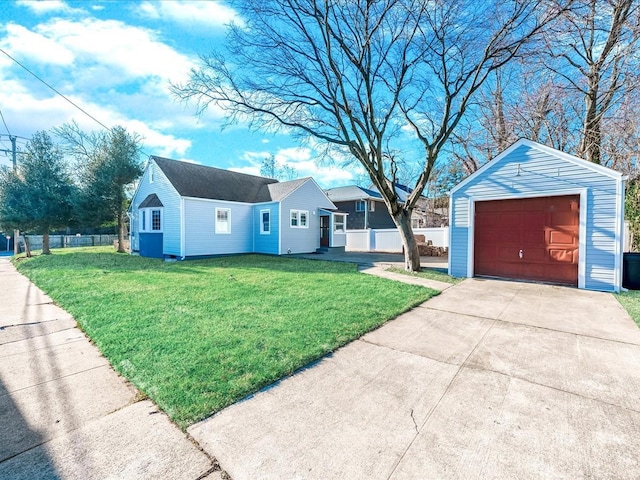 view of front of house with a front yard, a garage, and an outbuilding