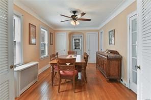 dining area featuring ceiling fan, ornamental molding, and hardwood / wood-style flooring