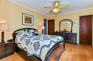 bedroom featuring ceiling fan, light wood-type flooring, and ornamental molding