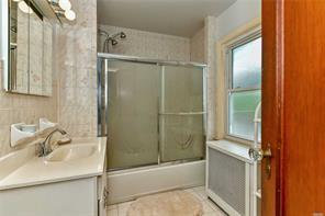 bathroom featuring bath / shower combo with glass door and vanity