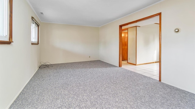 empty room featuring crown molding and light carpet