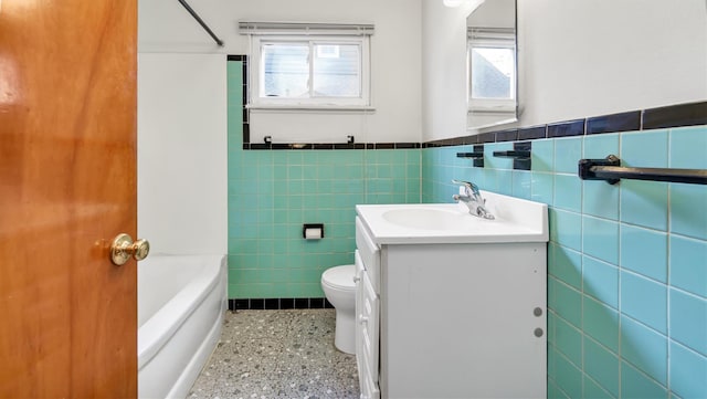 full bathroom with vanity, tile walls, and a wealth of natural light