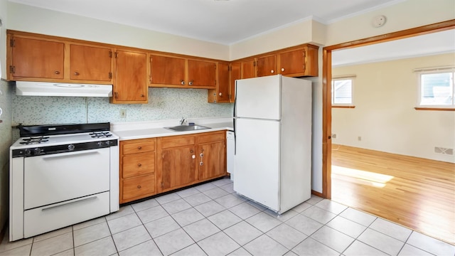 kitchen featuring light tile patterned floors, decorative backsplash, sink, and white appliances