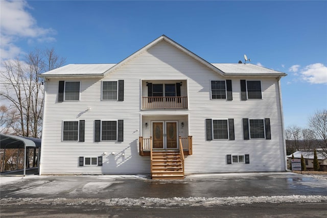 view of front facade featuring a carport, a balcony, and french doors