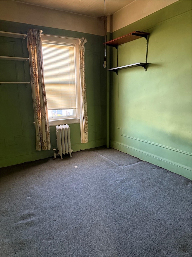 carpeted empty room featuring radiator