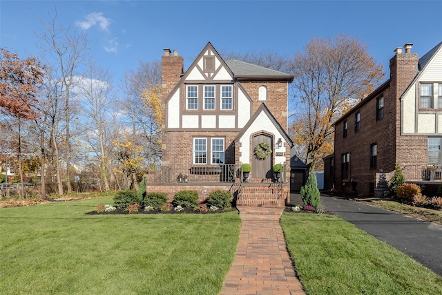 tudor home with a front lawn