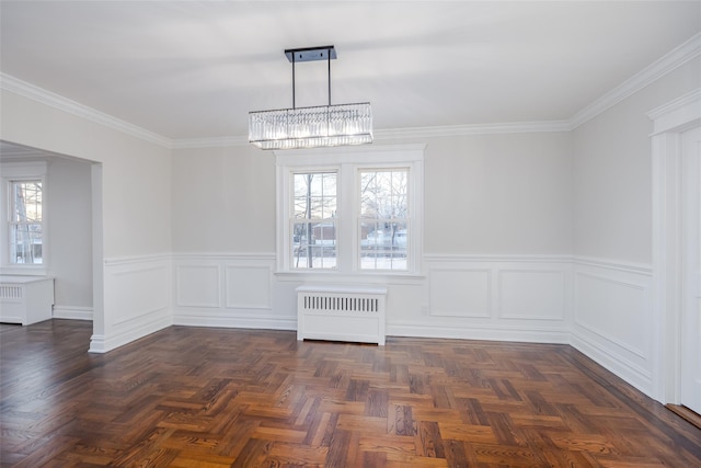 unfurnished dining area featuring ornamental molding, a notable chandelier, radiator heating unit, and dark parquet floors