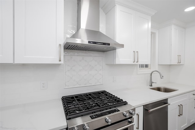 kitchen featuring wall chimney exhaust hood, sink, tasteful backsplash, stainless steel appliances, and white cabinets